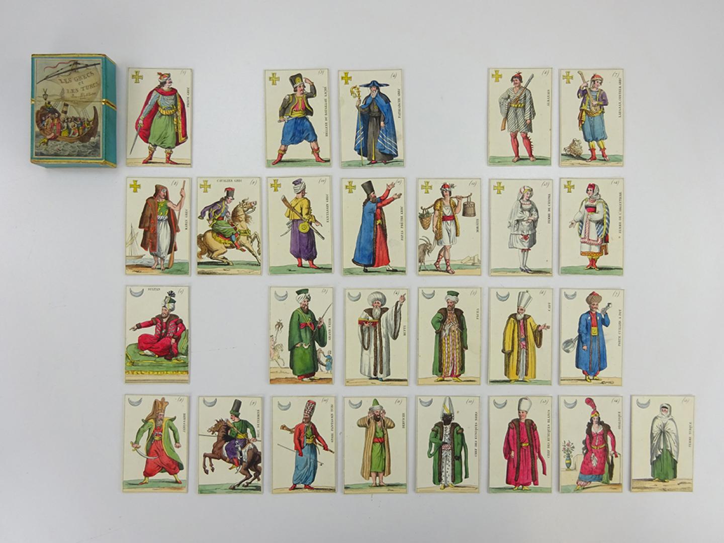 Jeu de 30 cartes, sa boîte et ses règles Les Grecs et les Turcs. Jeu-problème, 1821-1840 Provenant de la famille Grand d’Hauteville, Château d’Hauteville, Saint-Légier (VD) Papier coloré et doré, H. 7,5, l. 5 cm, Inv. 7050.0 © Musée Suisse du Jeu, La Tour-de-Peilz, photo : J. Demotz